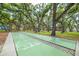 Shuffleboard court surrounded by mature trees and greenery, offering a peaceful setting at 3595 41St S Ln # L, St Petersburg, FL 33711