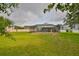 Expansive backyard view showcasing a screened in pool and spa, lush green lawn, and a peaceful outdoor space at 3634 Springville Dr, Valrico, FL 33596