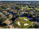 Aerial view of homes bordering a golf course with water and sand features at 395 Forest Park Rd, Oldsmar, FL 34677