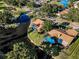 Aerial view of residential houses with pools in a lush neighborhood, along a pond at 395 Forest Park Rd, Oldsmar, FL 34677