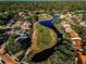An aerial view showcases the lush golf course surrounded by homes, trees and winding water features at 395 Forest Park Rd, Oldsmar, FL 34677