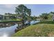 Waterfront backyard features lush lawn, mature trees, and a tranquil view at 395 Forest Park Rd, Oldsmar, FL 34677