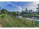 Scenic backyard with a black metal fence separating the yard from a tranquil pond at 395 Forest Park Rd, Oldsmar, FL 34677