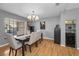 Well-lit dining room with seating for six, chandelier, and wine storage unit at 395 Forest Park Rd, Oldsmar, FL 34677