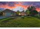 Charming home with a well-manicured lawn, a red door, and mature landscaping at 395 Forest Park Rd, Oldsmar, FL 34677