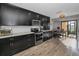 The kitchen has black cabinets and stainless steel appliances with a dining nook and sliding glass doors at 395 Forest Park Rd, Oldsmar, FL 34677