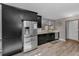 A modern kitchen with stainless steel appliances and sleek, black cabinetry and light wood colored floors at 395 Forest Park Rd, Oldsmar, FL 34677