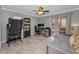 Versatile living space features a ceiling fan, workstation, and access to the outdoor patio at 395 Forest Park Rd, Oldsmar, FL 34677