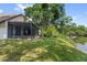 Home backyard features a screened enclosure, lush lawn and pond access at 4013 Muriel Pl, Tampa, FL 33614