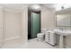 Bathroom with modern glass shower, white cabinets and pedestal sink at 4013 Muriel Pl, Tampa, FL 33614