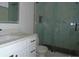Bathroom with single sink vanity, toilet, and walk-in glass shower with tile at 4101 W Mango Ave, Tampa, FL 33616