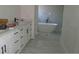 Bathroom with double sink vanity, cabinets with black hardware, freestanding tub, and glass-enclosed shower at 4101 W Mango Ave, Tampa, FL 33616