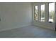 Empty bedroom with three large windows offering bright light and serene view of outside greenery at 4101 W Mango Ave, Tampa, FL 33616