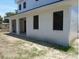 Side view of a modern home with dark-trimmed windows, columns, and a stucco finish at 4101 W Mango Ave, Tampa, FL 33616
