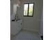 Laundry room with sink, cabinet, black hardware, and a window with views of outside greenery at 4101 W Mango Ave, Tampa, FL 33616