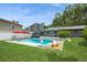 A backyard featuring a fenced in kidney shaped pool, umbrellas, patio set and well maintained grass at 4204 Northwind Ln, Tampa, FL 33624