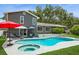 Aerial of a kidney shaped pool featuring a hot tub and a lounge area behind the house at 4204 Northwind Ln, Tampa, FL 33624