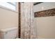 This walk-in shower features a decorative tile border and shower curtain with a leafy pattern at 4204 Northwind Ln, Tampa, FL 33624
