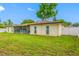 Large backyard featuring lush green grass and an extended, screened patio, perfect for outdoor activities at 4220 Woodlark Dr, Tampa, FL 33624