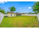 Expansive backyard with well-maintained lawn and a white fence at 4220 Woodlark Dr, Tampa, FL 33624