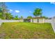 Large backyard featuring lush grass, a white fence, and mature trees at 4220 Woodlark Dr, Tampa, FL 33624