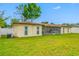 Spacious backyard with well-maintained lawn, screened patio and white fence at 4220 Woodlark Dr, Tampa, FL 33624