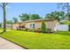 Attractive home featuring a manicured lawn, mature landscaping, and a combination of siding and stone accents at 4220 Woodlark Dr, Tampa, FL 33624