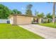 Well-maintained home with an attached garage, a spacious driveway, and a lush green lawn at 4220 Woodlark Dr, Tampa, FL 33624