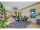 This covered patio features tile flooring, a ceiling fan, and a table for outdoor dining at 4220 Woodlark Dr, Tampa, FL 33624