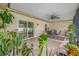 Inviting screened patio with tile flooring, ceiling fan, plants, and outdoor seating, perfect for relaxation at 4220 Woodlark Dr, Tampa, FL 33624
