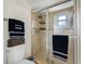 Modern bathroom with tile shower, glass door, and convenient shelving at 4220 Woodlark Dr, Tampa, FL 33624