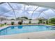 A refreshing screened-in swimming pool with a white frame, perfect for outdoor relaxation and enjoyment at 4368 Las Palmas Ave, Spring Hill, FL 34606