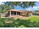 Spacious backyard featuring a screened-in patio, lush green grass, and mature trees at 4418 River Overlook Dr, Valrico, FL 33596