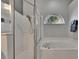 Bathroom featuring a shower, garden tub, and a half moon window at 4418 River Overlook Dr, Valrico, FL 33596