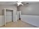 Neutral bedroom featuring carpet floors, closet, wainscoting and a ceiling fan at 4418 River Overlook Dr, Valrico, FL 33596