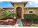 Inviting front entrance with a beautiful arched entryway, decorative plants and a welcoming welcome sign at 4418 River Overlook Dr, Valrico, FL 33596