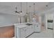 Open kitchen with modern appliances, breakfast bar and lighting with an adjacent utility room at 4418 River Overlook Dr, Valrico, FL 33596