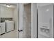 Convenient laundry room with a washing machine and dryer, next to a pantry and refrigerator at 4418 River Overlook Dr, Valrico, FL 33596