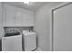 Convenient laundry room equipped with modern washer and dryer and overhead storage cabinets at 4418 River Overlook Dr, Valrico, FL 33596