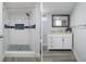 Updated bathroom with walk-in shower, modern vanity, gray flooring, and decorative mirror at 500 New York Ave # 23, Dunedin, FL 34698