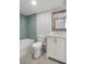 Bright bathroom featuring a tiled shower-tub, white vanity, and decorative wood-framed mirror at 500 New York Ave # 23, Dunedin, FL 34698