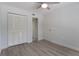 Bedroom with ceiling fan, light wood floors, and white closet with louvered doors at 500 New York Ave # 23, Dunedin, FL 34698