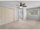 Bright bedroom features a ceiling fan, closet, neutral carpet, and ensuite bathroom access at 500 New York Ave # 23, Dunedin, FL 34698