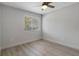 Neutral bedroom featuring light wood floors, a ceiling fan, and bright window at 500 New York Ave # 23, Dunedin, FL 34698