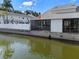 Home situated along the water featuring a screened porch and a white picket fence at 500 New York Ave # 23, Dunedin, FL 34698