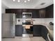 Modern kitchen featuring stainless steel appliances, granite countertops, and dark wood cabinets at 500 New York Ave # 23, Dunedin, FL 34698