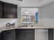 Kitchen featuring stainless steel appliances, granite countertops, and a breakfast bar with lake view at 500 New York Ave # 23, Dunedin, FL 34698