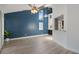 Bright living room featuring wood floors, a ceiling fan, and a view into the kitchen at 500 New York Ave # 23, Dunedin, FL 34698