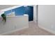 Neutral loft featuring blue accent wall, light carpet, and railing overlooking below at 500 New York Ave # 23, Dunedin, FL 34698