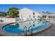 Community pool with plenty of seating and lounge chairs on a sunny day at 500 New York Ave # 23, Dunedin, FL 34698